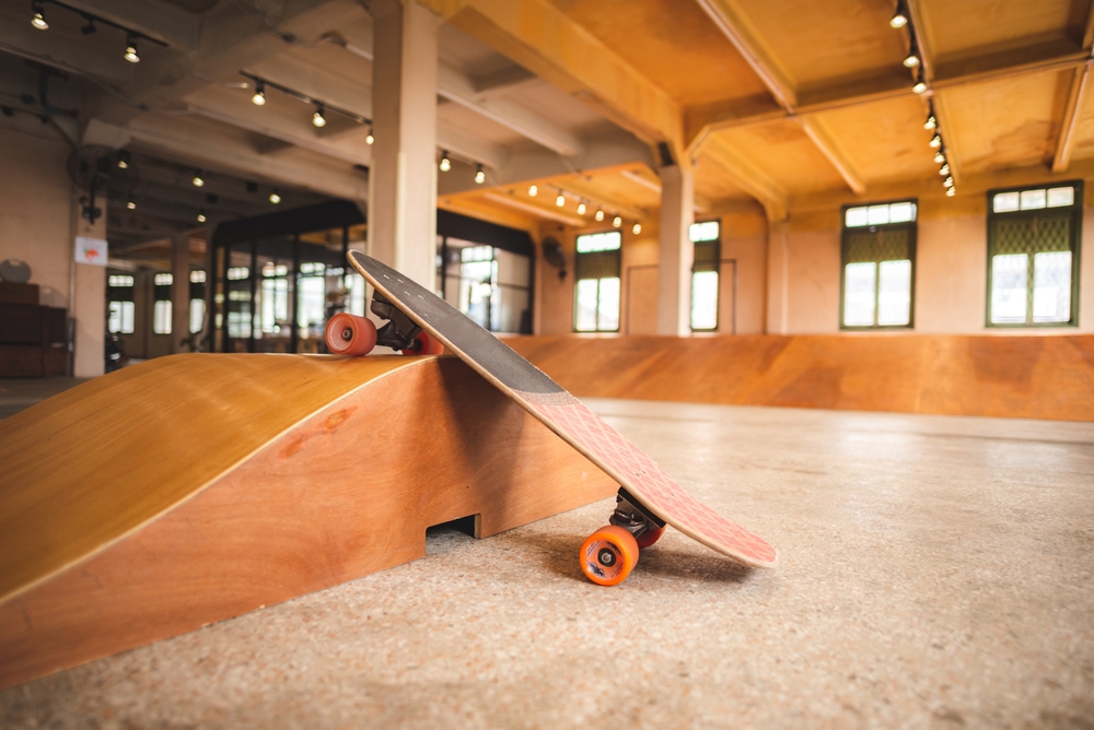 Skateboard Resting on Indoor Skatepark Ramp - Thomas Augusto Skateboard placed on a wooden ramp inside an indoor skatepark, highlighting design, texture, and skating environment. - Thomas Augusto